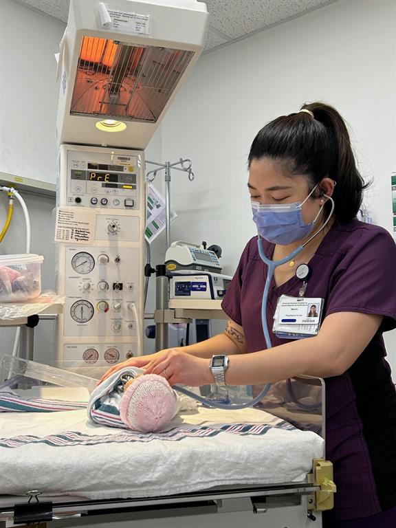 Nurse checkgin vital signs on a newborn